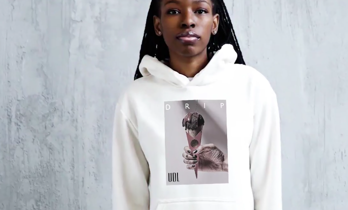A person wearing a white hoodie with a graphic print of an ice cream cone and the word "DRIP" on it.
