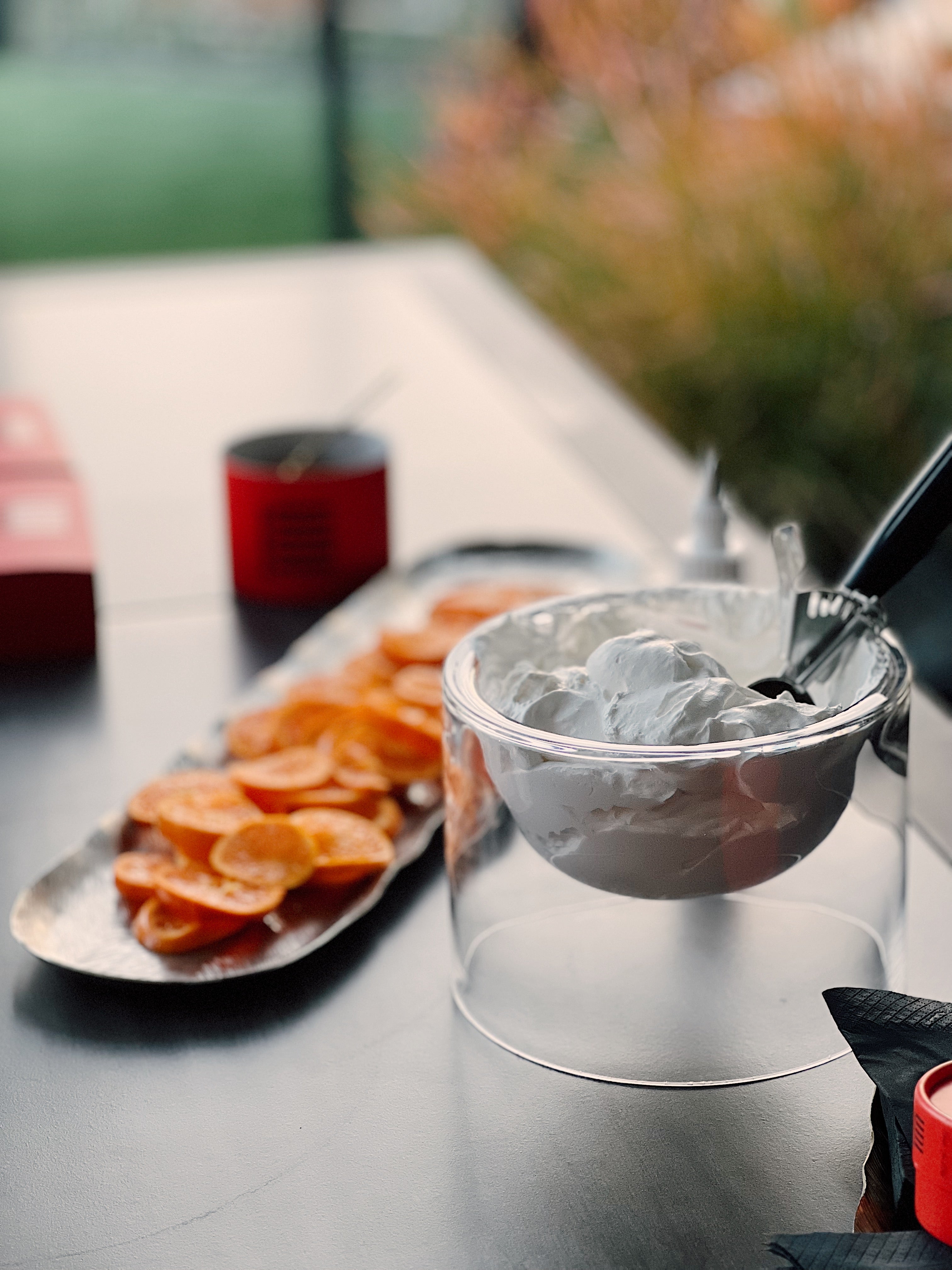 Orange slices on a tray and a bowl of dessert creme. Urban Dessert Lab branded packaging in the background.