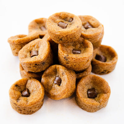 A pile of small, round chocolate chip cookies with a soft, golden-brown texture.