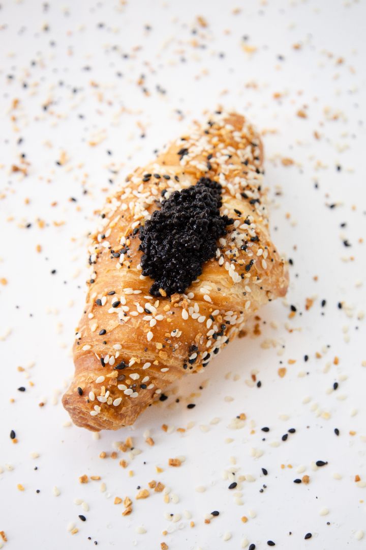 Photo of a seaweed caviar croissant on a white background 