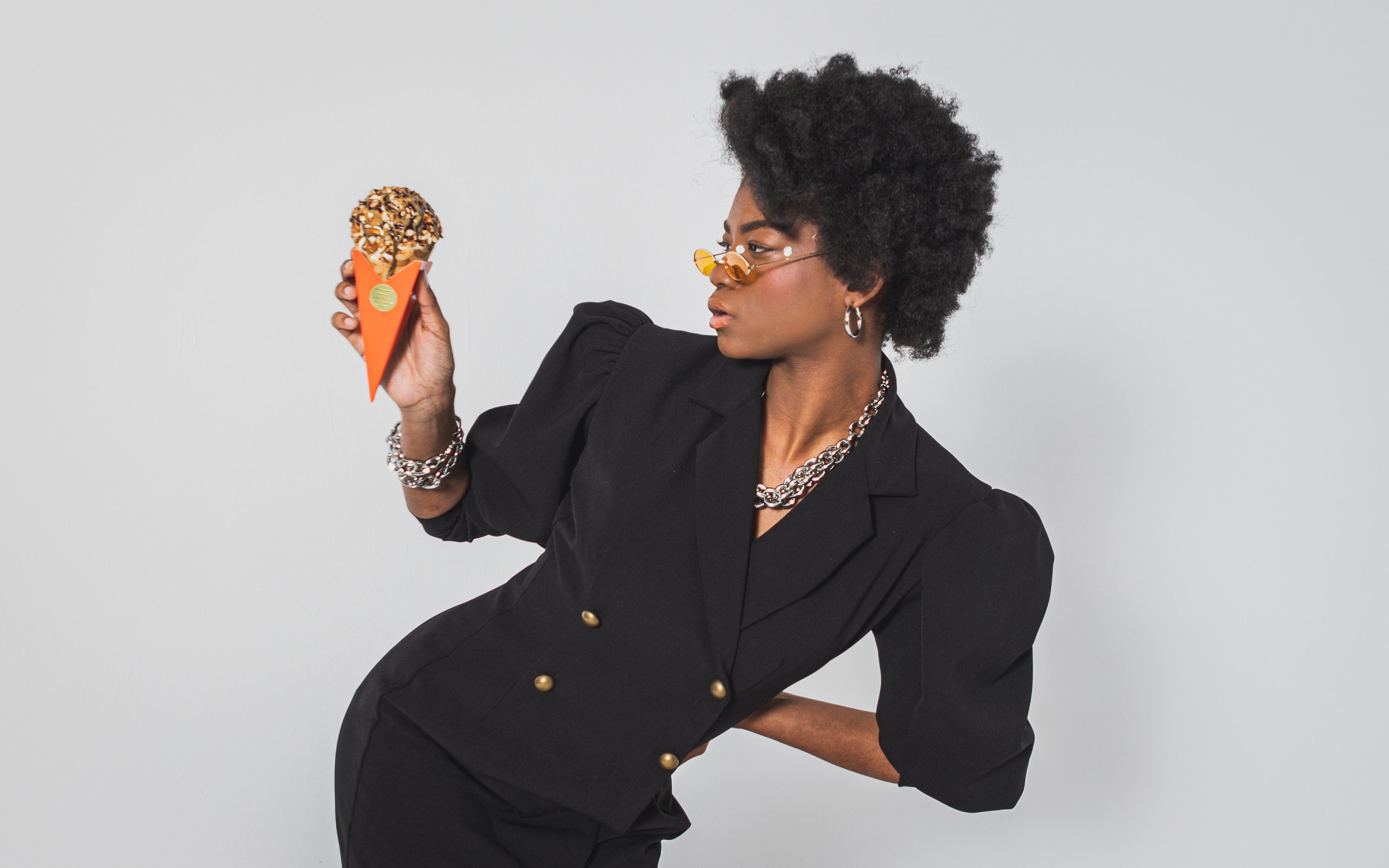 Model holding and looking at an ice creme cone with a fierce pose